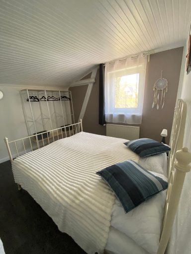 Schlafzimmer mit offenem Kleiderschrank